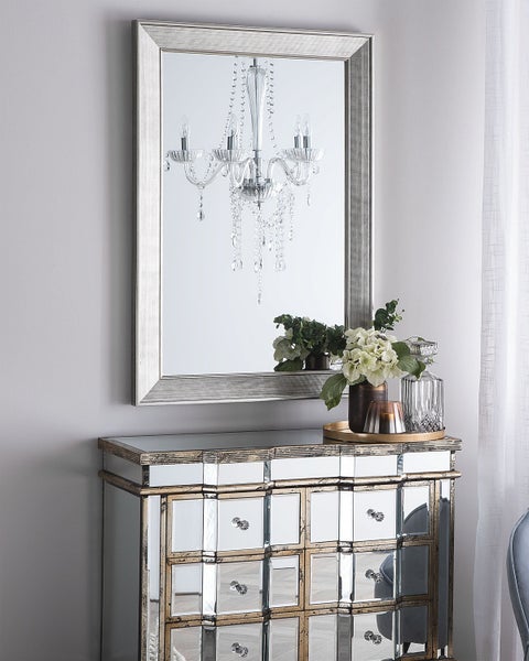 Rechteckiger Spiegel über einem Schrank mit Spiegelfront und Schubladen