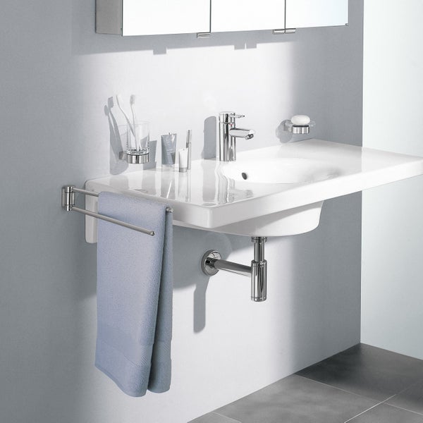Modernes Badezimmer mit weißem Waschbecken, verchromter Armatur und schwenkbarem Handtuchhalter an der Wand befestigt.