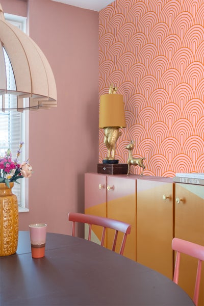 Esszimmer mit Esstisch, Stühlen, Kommode und dekorativer Tapete