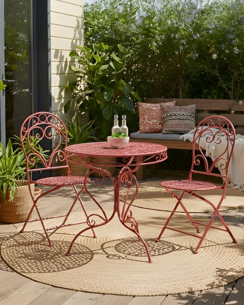 Gartenszene mit einem kleinen Tisch und zwei Stühlen auf einem Teppich im Freien