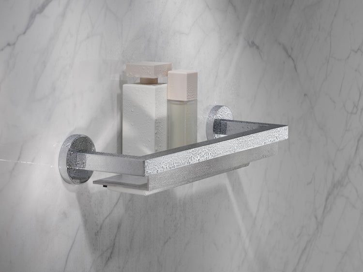 Wandmontiertes Duschregal aus Metall mit quadratischem Design vor einer gefliesten Wand mit zwei Kosmetikflaschen