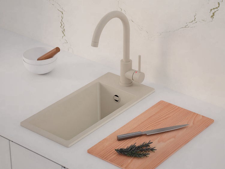 Moderne Einbauspüle mit Hochdruck-Armatur in Granit-Optik auf einer hellen Arbeitsplatte mit Schneidebrett aus Holz.