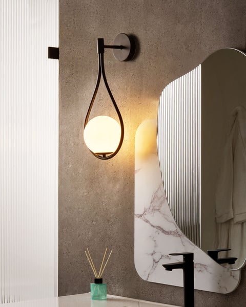 Badezimmer mit Wandleuchte, Spiegel und Waschtisch