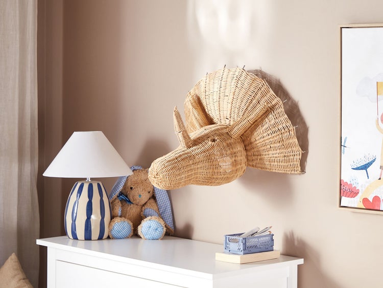 Kinderzimmer Szene mit geflochtenem Nashornkopf, Lampe, Spielzeug und Aufbewahrungsbox auf einem weißen Schrank