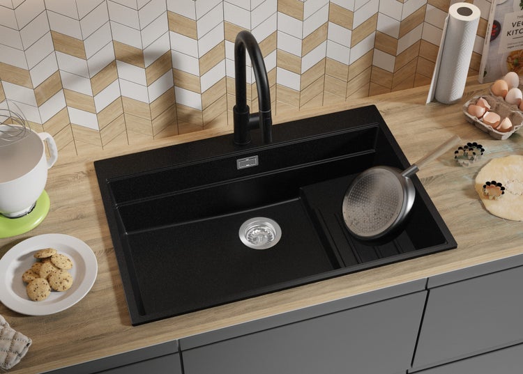 Schwarzes Spülbecken mit Armatur in einer hellen Küche