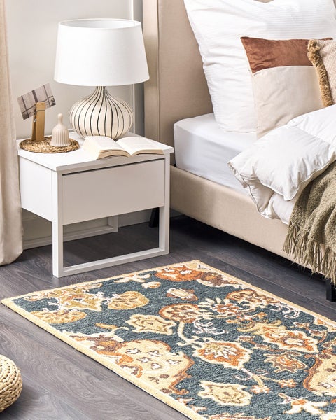 Geräumiges Gartenhaus aus hellem Holz mit Satteldach, Doppeltür und Fenster. Innen mit Sofa und Regal, außen mit Sitzgruppe und Rasenmäher.