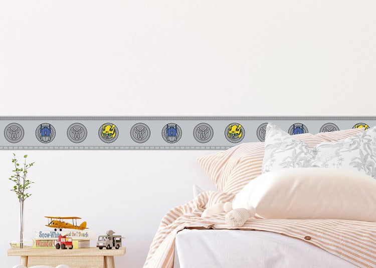Wandbordüre mit Transformers-Motiven wie Optimus Prime und Bumblebee in einem hellen Kinderzimmer.