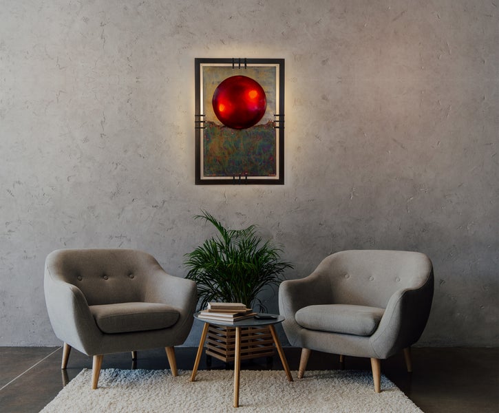 Wohnzimmer mit zwei Sesseln, einem Beistelltisch mit Pflanze und einem beleuchteten Wandbild