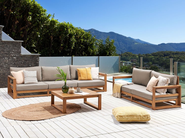 Gartenlounge-Set mit Sofa, Sessel und Tisch auf einer Terrasse mit Blick auf die Berge.