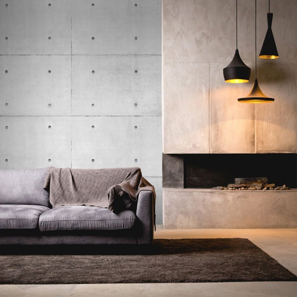 Wohnzimmer mit Betonwand, Sofa, Teppich, Kamin und Pendelleuchten