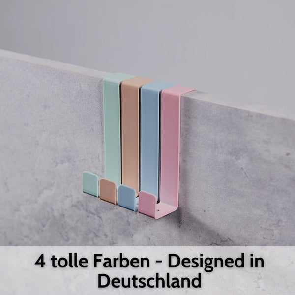 Vier verschiedenfarbige Türhaken aus Metall über eine Kante hängend. Entworfen in Deutschland.