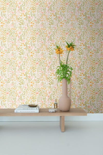 Gemusterte Tapete mit Blumenmuster und Holzkonsole mit Dekoration