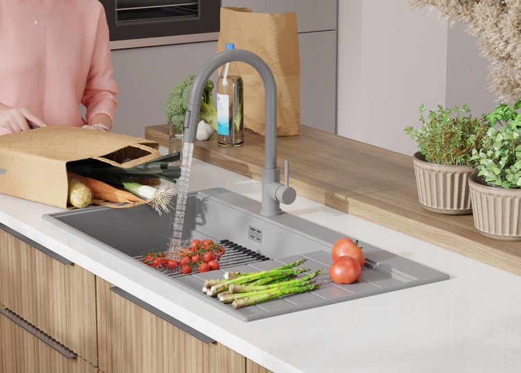 Küchenszene mit Spüle, Armatur und frischem Gemüse.