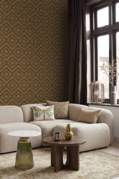 Wohnzimmer mit gemusterter Vliestapete, modernem Sofa, zwei Beistelltischen und Dekoration in einer eleganten und behaglichen Raumatmosphäre.
