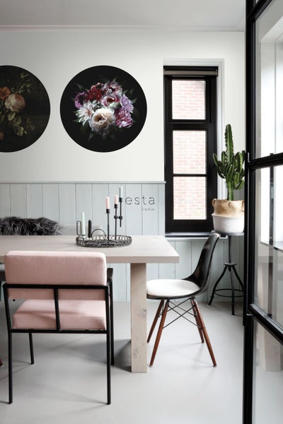 Esszimmer mit Esstisch, Stühlen, Wanddekoration und Zimmerpflanze
