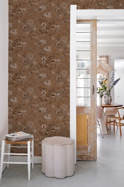 Dekoratives Wohnzimmer mit blumiger Tapete, Hocker und Beistelltisch