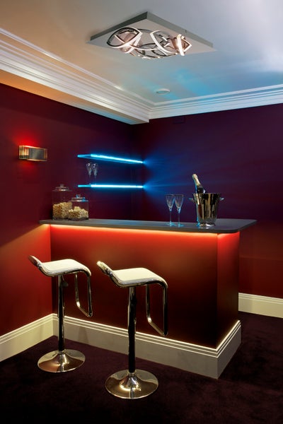 Bar mit Barhockern, Regalen, Wandleuchte und Deckenleuchte für eine stimmungsvolle Atmosphäre