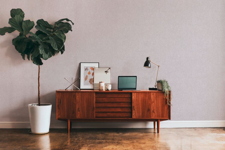 Schlafzimmer mit Bett, Leiter, Korbsessel und Flechtkorb für Wäsche