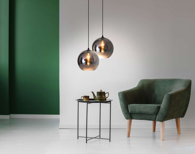 Dekoratives Wohnzimmer mit Sessel, Beistelltisch und Hängeleuchten