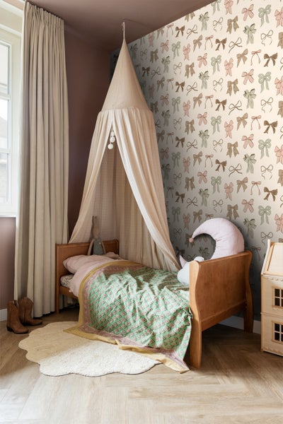 Kinderzimmer mit Bett, Baldachin, gemusterter Tapete und Teppich