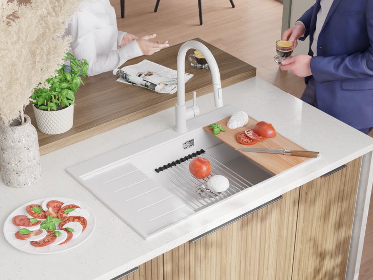 Küchenszene mit Spüle, Armatur, Schneidebrett, Tomaten und Mozzarella