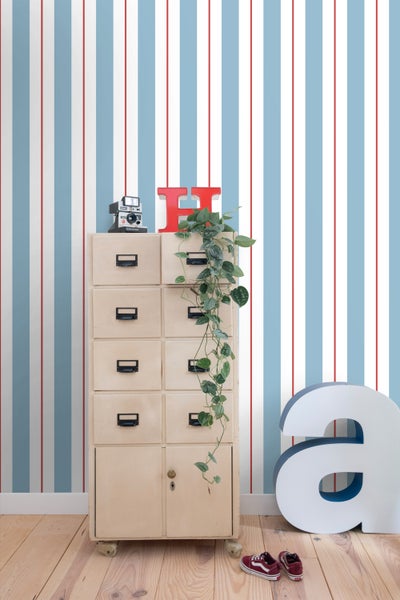 Zimmer Szene mit Schrank, Dekoration und gestreifter Tapete