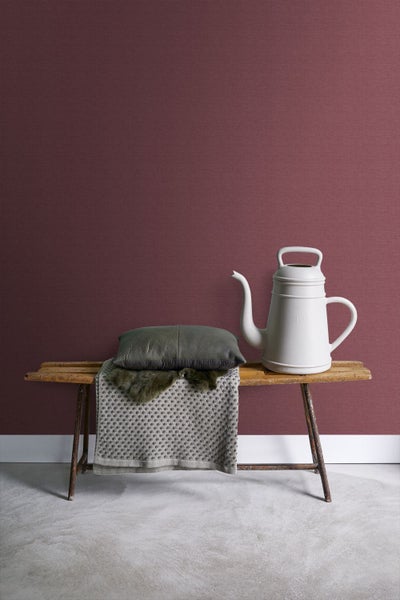 Szene mit Dekoration auf einer Holzbank vor einer Wandtapete.