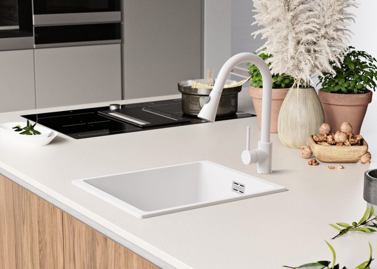 Küchenszene mit Spüle, Armatur, Kochfeld und Dekorationselementen