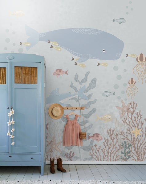 Kinderzimmer mit Meeresmotivtapete, blauem Kleiderschrank und Accessoires