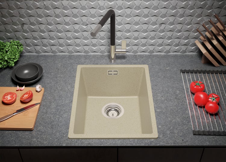 Küchenspüle mit Armatur, Schneidebrett, Abtropfgestell und Lebensmitteln auf einer Küchentheke