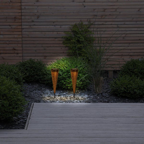 Beleuchtete Gartenszene mit zwei Solarleuchten zwischen Pflanzen und Steinen