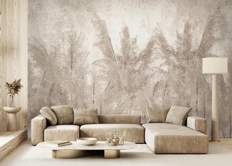 Hell gestaltetes, modernes Wohnzimmer mit großflächiger Fototapete mit Pampasgras-Motiv, modularem Ecksofa, ovalem Couchtisch und Stehlampe.