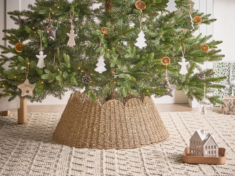 Geschmückter Weihnachtsbaum mit Baumständer aus geflochtenem Material