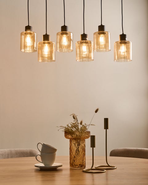 Esstisch mit sechsflammiger Pendelleuchte, Vase, Kerzenständer und Tassen