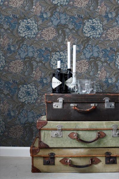 Dekorative Szene mit floraler Tapete, alten Koffern und Getränkeflaschen