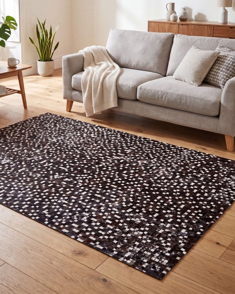 Ein moderner Teppich mit geometrischem Schachbrettmuster in einem hellen Wohnzimmer mit Sofa, Holzboden und Zimmerpflanze.