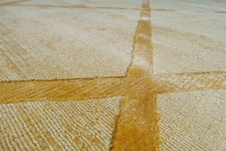Nahaufnahme eines gelben Teppichs mit geometrischem Linienmuster und strukturiertem, dichtem Flor.