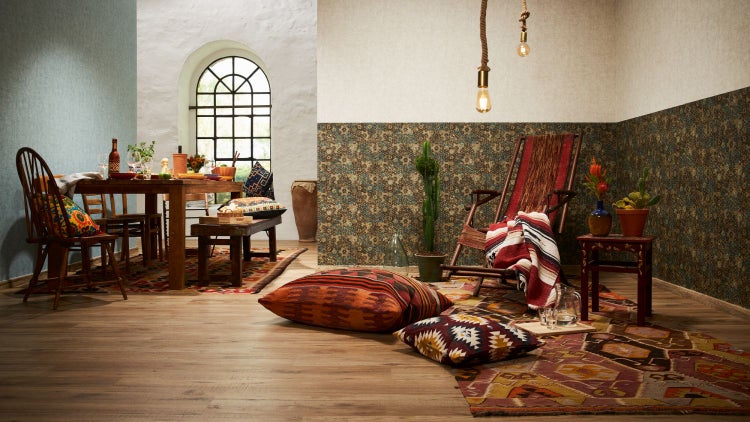 Wohnzimmer mit Rattansessel, Hocker und Textiltapete