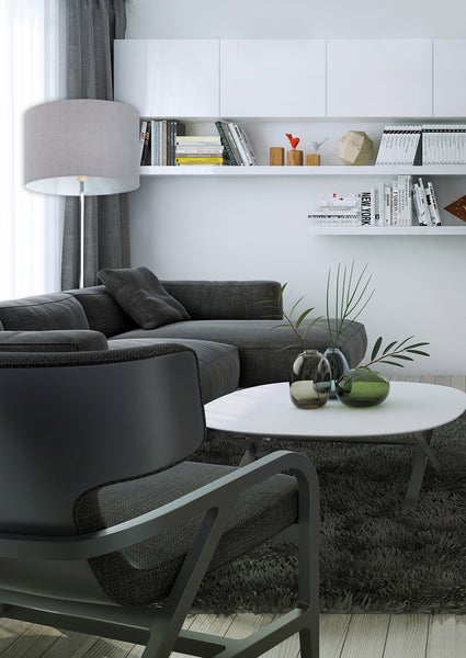Wohnzimmer mit Sofa, Sessel, Couchtisch, Stehlampe und Regalen