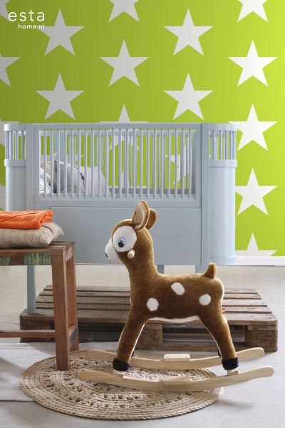 Szene mit Kinderbett, Stofftier-Schaukelreh und sternförmiger Tapete für ein Kinderzimmer