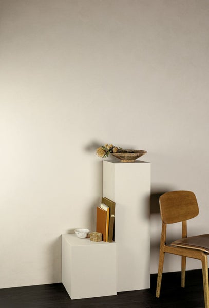 Weißes Aufsatzwaschbecken mit schwarzer Armatur vor einer blauen Wand