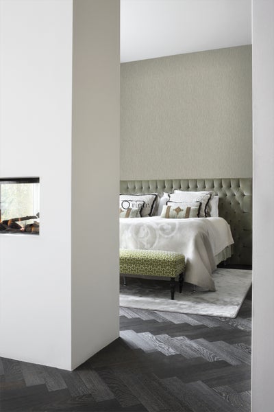 Ein Schlafzimmer mit einem Bett, einem Hocker und einem Kamin.