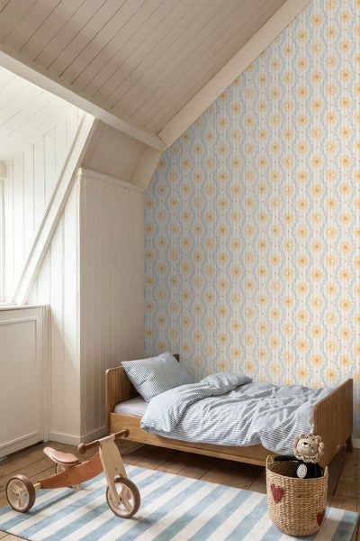 Helles Kinderzimmer im Dachgeschoss mit gemusterter Tapete, Holzbett, gestreifter Bettwäsche und Holzspielzeug auf einem gestreiften Teppich.