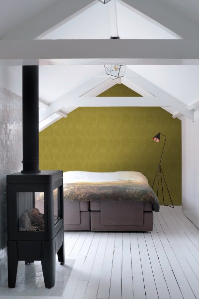 Helles Schlafzimmer im Dachgeschoss mit Kaminofen, Boxspringbett und Stehlampe