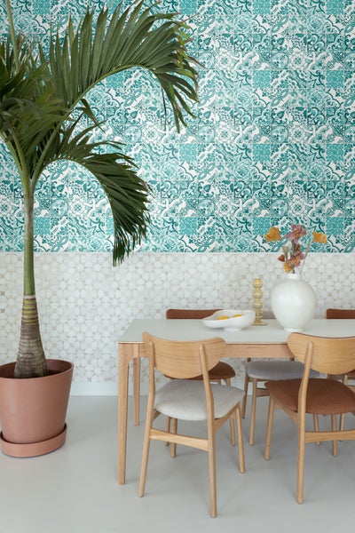 Esszimmer mit Esstisch, Stühlen und dekorativer Wandgestaltung