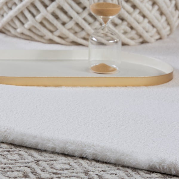Nahaufnahme eines weichen, weißen Hochflor-Teppichs aus Kunstfell.