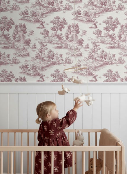 Vliestapete mit Toile-de-Jouy-Muster im Kinderzimmer über einer weißen Holzvertäfelung und einem Kinderbett aus Holz.