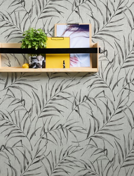 Wandregal mit Dekoration vor einer Tapete mit Pflanzenmuster