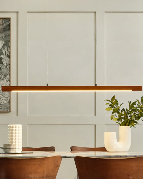 Hängende Holzleuchte über Esstisch mit Dekoration