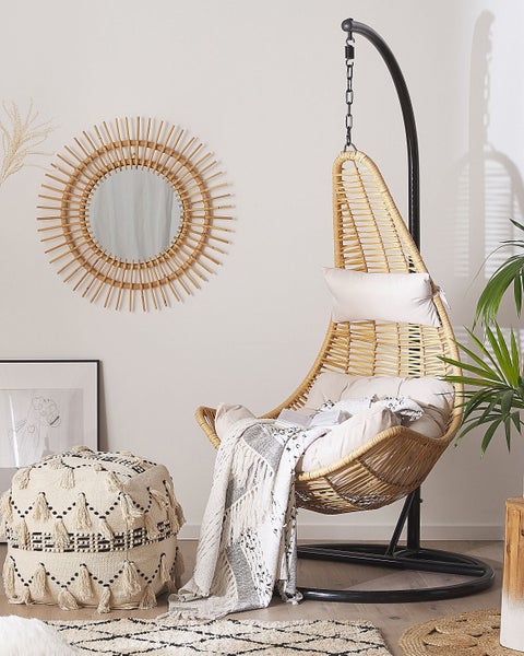 Einrichtungsidee mit Hängesessel aus Rattan, Pouf und Spiegel mit Sonnenmotiv
